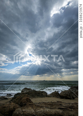 岩の上から見える海に光り射す 108623974