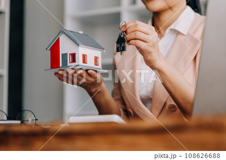 Real estate broker agent presenting and consult to customer to decision making sign insurance form agreement, buy and sell home model, concerning mortgage loan offer for and house insurance Real estate broker agent presenting and consult to customer to decision making sign insurance form agreement, buy and sell home model, concerning mortgage loan offer for and house insurance 108626688