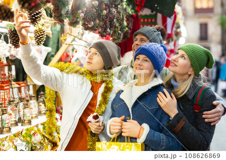 Family choosing Christmas decoration at Christmas market in evening 108626869