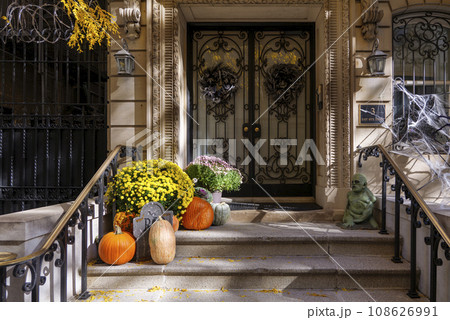 Colorful Pumpkins and Flowers on the Stairs of an Old Brownstone Home in New York City during Autumn 108626991