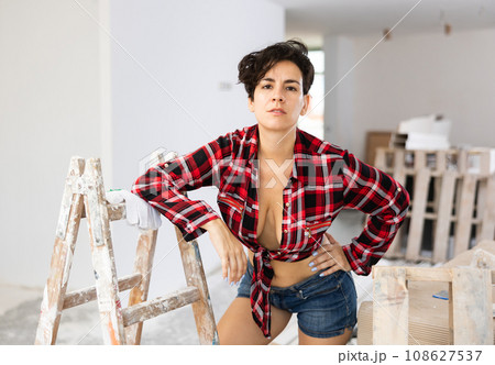 Young seductive woman wearing revealing clothes, posing in apartment during doing house repairs 108627537