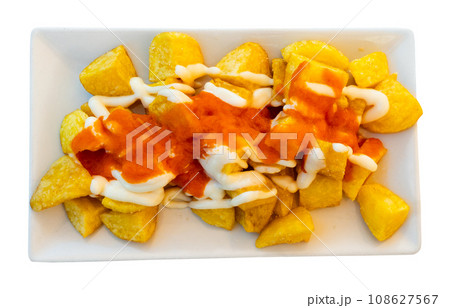 Spanish fried potatoes Patatas bravas served with cheese sauce 108627567