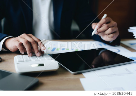 financial, Planning, Marketing and Accounting, portrait of Asian woman Economist using calculator to calculate investment documents with partners on profit taking to compete with other companies. financial, Planning, Marketing and Accounting, portrait of Asian woman Economist using calculator to calculate investment documents with partners on profit taking to compete with other companies. 108630443