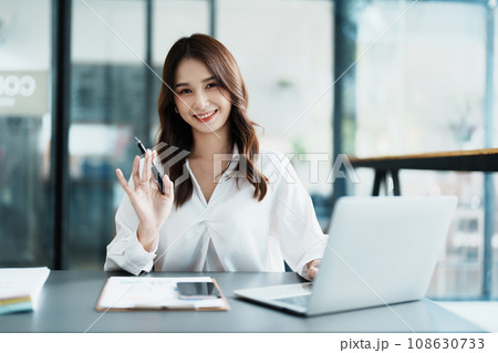 Portrait of a beautiful Asian teenage girl using computer for video conferencing at office. Portrait of a beautiful Asian teenage girl using computer for video conferencing at office. 108630733