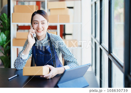 Starting small business entrepreneur of independent Asian female online seller packing products to send to customers and SME delivery concept. Starting small business entrepreneur of independent Asian female online seller packing products to send to customers and SME delivery concept. 108630739