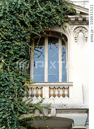 Beautiful French windows. Window frames with wooden shutters. Windows of a private house with flower pots and wooden shutters, Nice, France Beautiful French windows. Window frames with wooden shutters. Windows of a private house with flower pots and wooden shutters, Nice, France 108631521