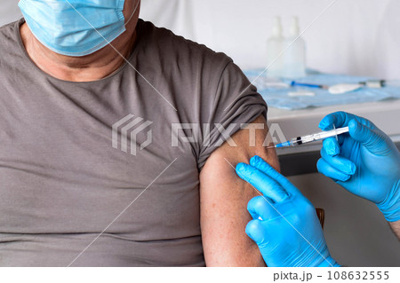 Elderly Man in Face Mask getting Covid Vaccine. Doctor giving Injection to senior Man at Hospital. Virus, COVID-2019, Flu protection. Vaccination of old Patient in Clinic during Coronavirus pandemic. Elderly Man in Face Mask getting Covid Vaccine. Doctor giving Injection to senior Man at Hospital. Virus, COVID-2019, Flu protection. Vaccination of old Patient in Clinic during Coronavirus pandemic. 108632555