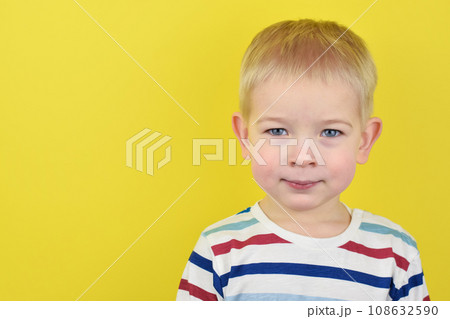 Happy smiling little boy on color background. Portrait of beautiful European boy two years old on a yellow background. Copy space for text. Happy smiling little boy on color background. Portrait of beautiful European boy two years old on a yellow background. Copy space for text. 108632590