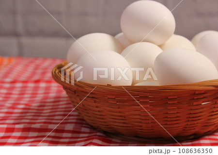 Basket of Farm Fresh Eggs on Red and White Checkered Fabric Basket of Farm Fresh Eggs on Red and White Checkered Fabric 108636350