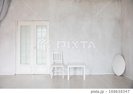 White Chair Coffee Table And Oval Mirror In Empty White Room Interior 108638347