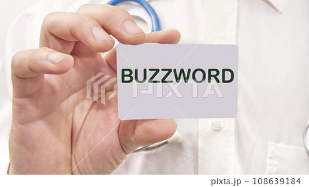 Buzzword word on the card in a man's hand on the background of a white shirt 108639184