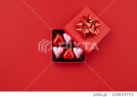Heart shaped chocolate candies in red gift box on the red background  108639753