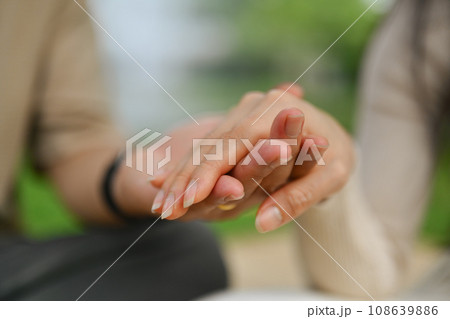 Caring young adult daughter holding hand of mature father showing love and support 108639886