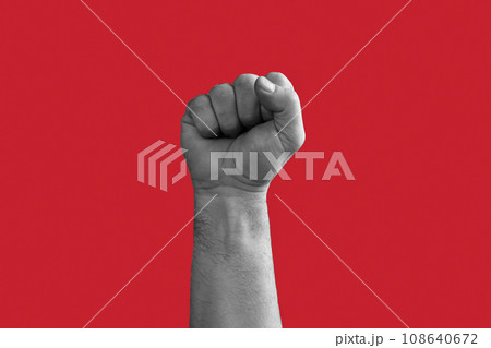 Black and White Man Hand with Raised Fist isolated on Red Background. Male Clenched Closed Fist. Revolution, Teamwork Power, Competition Concept. Hand Raised Up. Human Equal Rights, Freedom, Election 108640672