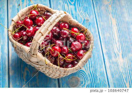 Fresh cherries in a wicker basket. 108640747