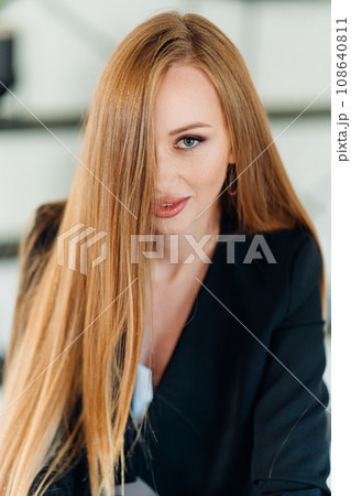 portrait of a Beautiful businesswoman with long red hair in black business suit. portrait of a Beautiful businesswoman with long red hair in black business suit. 108640811
