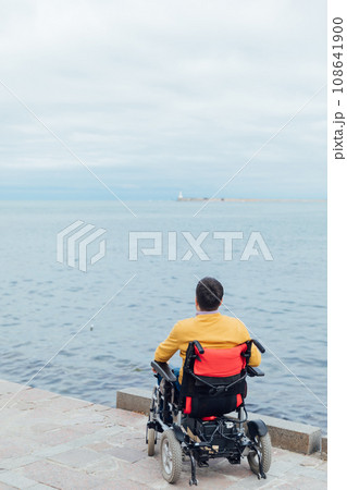 A man with disabilities breathes sea air by the sea A man with disabilities breathes sea air by the sea 108641900