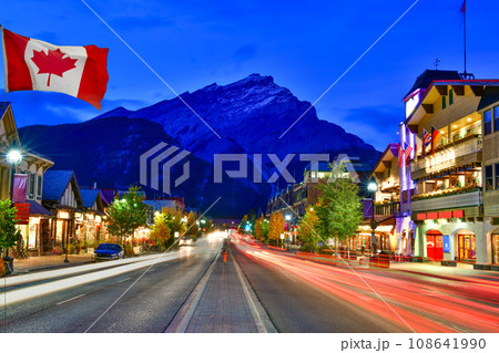 Canadian flag with Banff Avenue at twilight time, Alberta, Canada Canadian flag with Banff Avenue at twilight time, Alberta, Canada 108641990