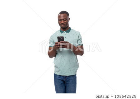portrait of a young short-haired American man dressed in a mint summer T-shirt with a smartphone in 108642829