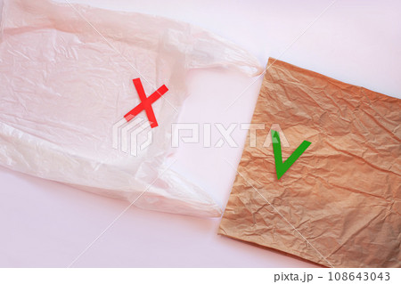 Blank plastic bag vs brown recyclable paper pack. Say no to plastic. Reduce, reuse and recycle concept.Eco friendly bag. 108643043