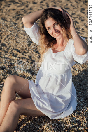 woman sitting on small pebbles on the beach rest walk 108643239