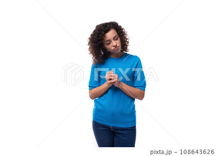 young woman with curly natural hair styling looks away thoughtfully 108643626