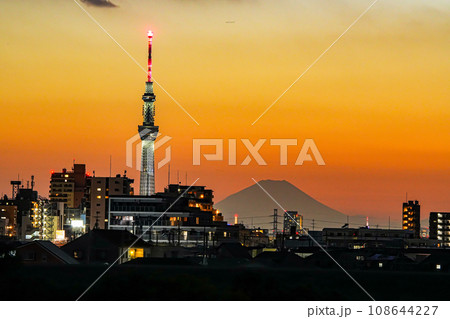 夕焼けに染まるスカイツリーと富士山と都市のシルエット 夕焼けに染まるスカイツリーと富士山と都市のシルエット 108644227