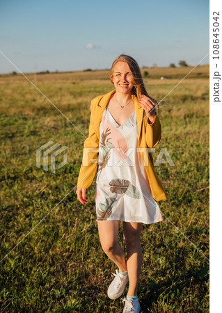 blonde woman in yellow clothes in nature green meadow blonde woman in yellow clothes in nature green meadow 108645042