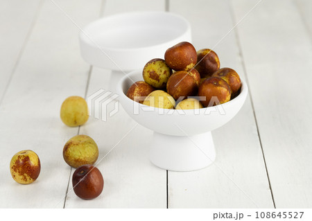 Green dates placed on a background board and served in a bowl. Green dates placed on a background board and served in a bowl. 108645527