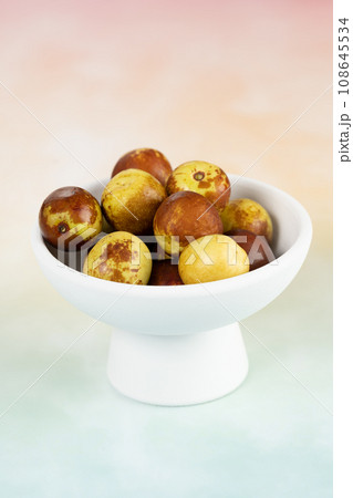 Green dates placed on a background board and served in a bowl. 108645534