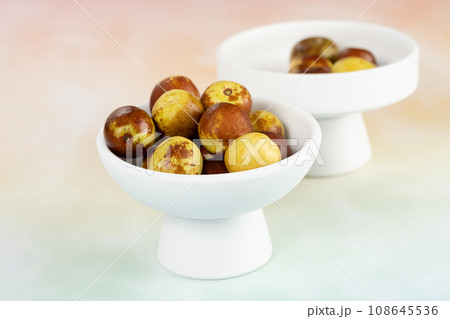 Green dates placed on a background board and served in a bowl. Green dates placed on a background board and served in a bowl. 108645536