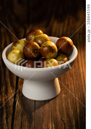 Sunlight shining on green dates on a wooden table board. Sunlight shining on green dates on a wooden table board. 108645599