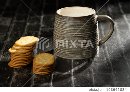 Sunlight shining on a slate board with a cup of milk and cookies. 108645824