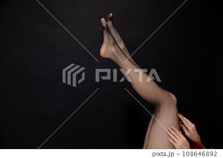 slender beautiful women's legs on a black background slender beautiful women's legs on a black background 108646892