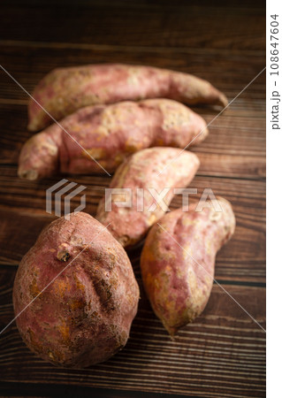Old sweet potatoes placed on a wooden board. Old sweet potatoes placed on a wooden board. 108647604