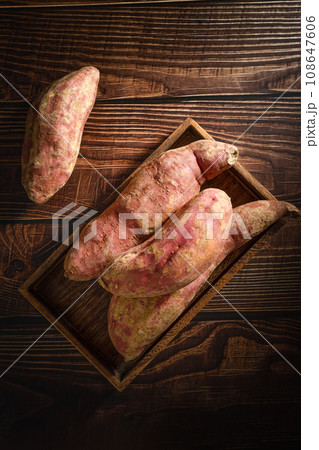 Old sweet potatoes placed on a wooden board. Old sweet potatoes placed on a wooden board. 108647606