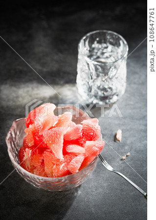 Sunlight shining on grapefruits with red flesh placed on a slate board in a bowl. Sunlight shining on grapefruits with red flesh placed on a slate board in a bowl. 108647761
