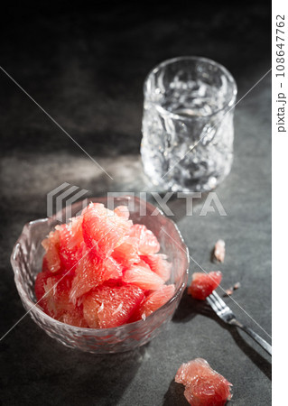 Sunlight shining on grapefruits with red flesh placed on a slate board in a bowl. Sunlight shining on grapefruits with red flesh placed on a slate board in a bowl. 108647762