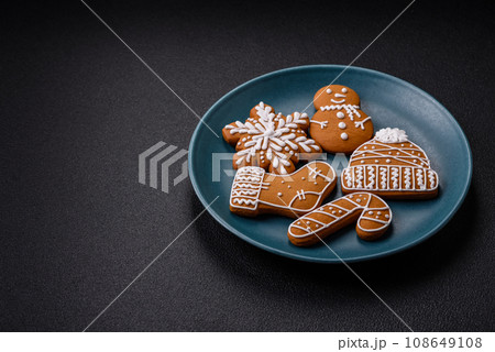 Beautiful Christmas gingerbread cookies of different colors on a ceramic plate Beautiful Christmas gingerbread cookies of different colors on a ceramic plate 108649108
