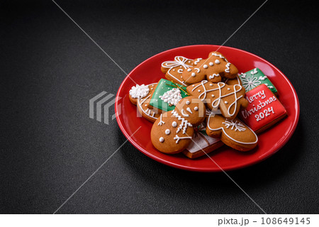 Beautiful Christmas gingerbread cookies of different colors on a ceramic plate 108649145