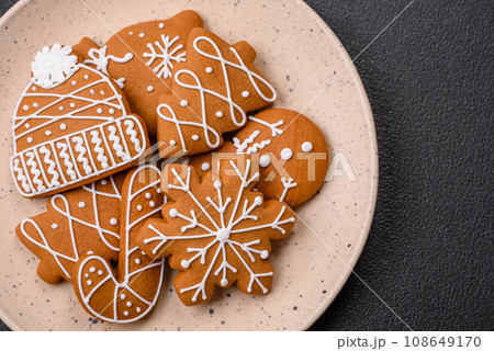 Beautiful Christmas gingerbread cookies of different colors on a ceramic plate 108649170