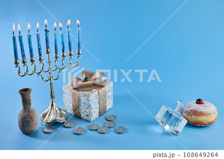 Jewish holiday Hanukkah with menorah, traditional Candelabra, donut and dreidel, spinning top. 108649264