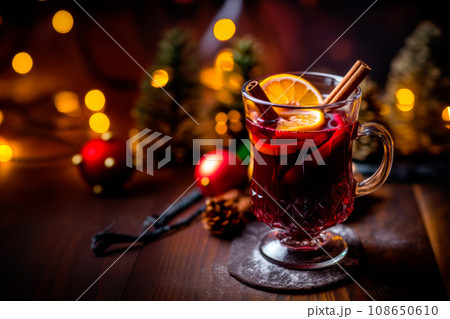 Christmas red mulled wine in a cup with cinnamon sticks, orange slices and winter decorations on wooden background Christmas red mulled wine in a cup with cinnamon sticks, orange slices and winter decorations on wooden background 108650610