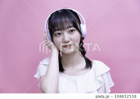 ヘッドホンでスマホの音楽を聴く若い女性 ヘッドホンでスマホの音楽を聴く若い女性 108652538