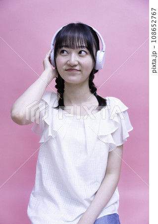 ヘッドホンでスマホの音楽を聴く若い女性 108652767