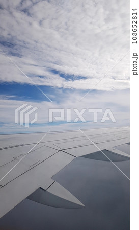 wing of airplane flying above the clouds 108652814