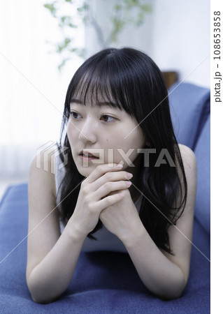 ソファーに寝転んでくつろぐ若い女性 ソファーに寝転んでくつろぐ若い女性 108653858