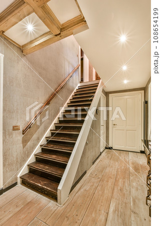 an empty room with wood flooring and white walls, stairs leading up to the second floor in this house 108654199