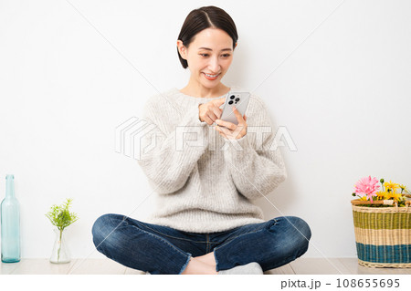 スマートフォンを操作する若い女性　ライフスタイルイメージ 108655695