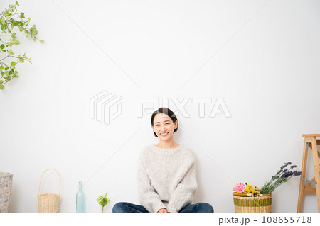 壁にもたれかかって座る若い女性　ライフスタイルイメージ 108655718